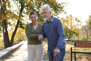 Caregiver assisting senior man in park. Home health care service