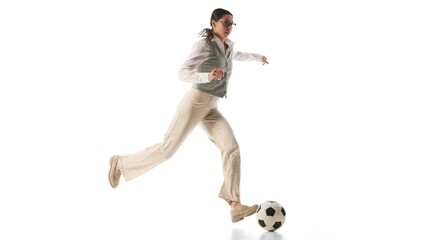 Fototapeta premium Woman kicks soccer ball mid-air with elegance and precision, representing balance and goal-oriented drive against white studio background. Concept of business agility, leadership, multitasking.