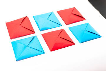 Square envelope made of red and blue paper. Origami envelope on white background