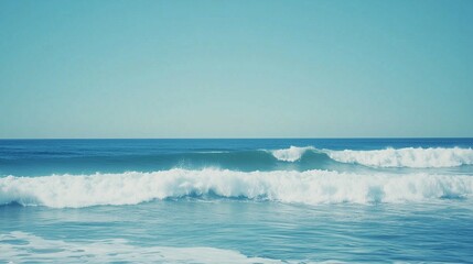 Close-up of a massive blue wave in the ocean with white foam, isolated against a clear sky background. This image could be used as a banner design.