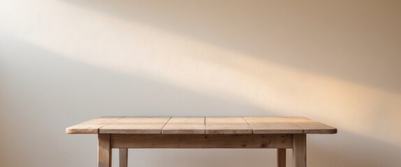 a simple wooden table with soft sunlight hitting the white wall in the background