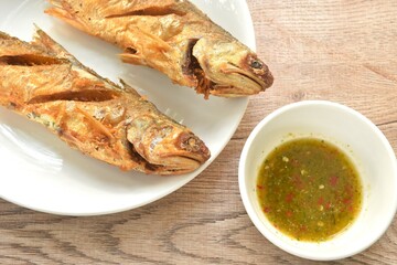 deep fried four finger threadfin fish dipping Thai spicy seafood sauce on plate