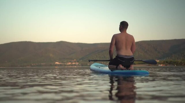 a tranquil scene featuring a person paddleboarding