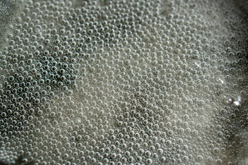 Clear water at the very beginning of the boiling process. A lot of steam bubbles have formed at the...