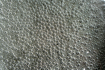 Clear water at the very beginning of the boiling process. A lot of steam bubbles have formed at the...