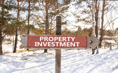 Property investment symbol. Concept words Property investment on beautiful wooden road sign. Beautiful winter forest snow tree background. Business Property investment concept. Copy space.