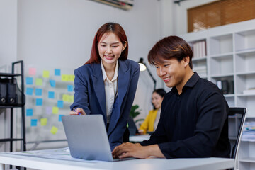 Smiling businessman working on a laptop computer in a modern office,doing finances, accounting analysis, report data pointing graph Freelance education and technology concept.	