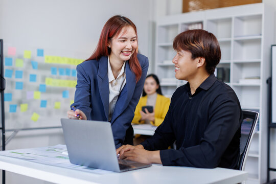 Smiling businessman working on a laptop computer in a modern office,doing finances, accounting analysis, report data pointing graph Freelance education and technology concept.	