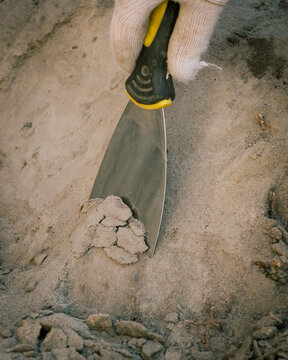 cleaning of an archaeological site (sand removal with a spatula)