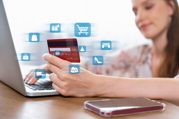 Elegant customer wearing floral shirt holding credit card choose online platform. Smart consumer typing laptop while open e-commerce application use cashless technology shopping inventory. Cybercash.