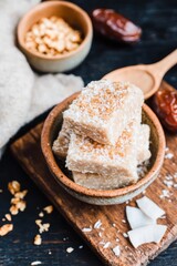 Rustic ceramic dish with homemade amaranth bars sprinkled with coconut flakes