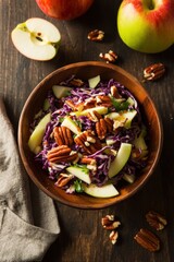 Fresh red cabbage salad with apples and pecans in a rustic wooden bowl