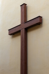 Large wooden cross mounted on a plain wall in a quiet interior space