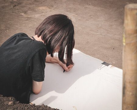 An archaeologist records an archaeological excavation (drawing an excavation plan)