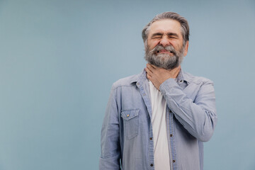 Fototapeta premium Senior man suffering from throat pain is touching his neck