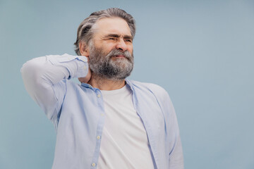Fototapeta premium Senior man suffering from neck pain touching his aching body part