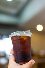 Hand hold a glass of iced americano. Stop using Plastic straws ready to drink.