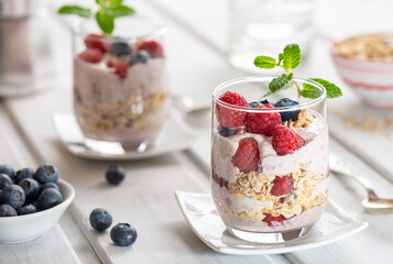 Healthy dessert with raspberries and yogurt layered in glasses