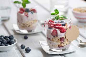 Healthy dessert - raspberries with yogurt layered in glasses and a cardboard sign for text