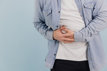 Senior man suffering from abdominal pain on blue background
