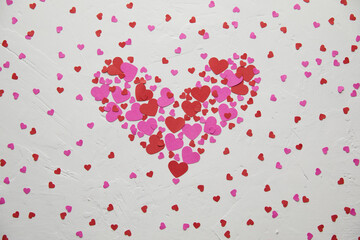 Heart-Shaped Arrangement of Red and Pink Hearts on Textured White Background