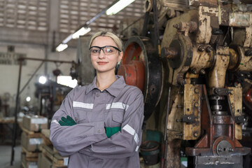 Portrait of factory woman worker at work in the industry factory. Female engineer standing with crossed arms at factory