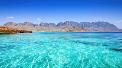Fototapeta premium Tranquil Turquoise Ocean with Mountain View
