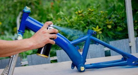 Spray Painting a Bicycle Frame Outdoors