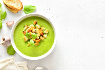 Spinach soup with croutons in white bowl