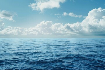 Obraz premium Calm ocean waves rolling under a bright blue sky dotted with fluffy white clouds, creating a serene and peaceful seascape