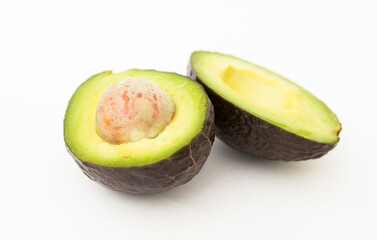 Halved avocado with bone on white background