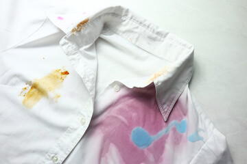 White dirty shirt with spots on light background         