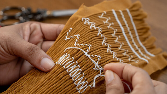 Smocking in Progress: Hand Stitches on Pleated Fabric for Dressmaking.