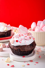 Valentine day tasty double chocolate cupcakes treat with whipped cream, heart shaped marshmallow and sugar sprinkles