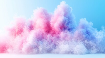 Fototapeta premium Fluffy pastel pink and blue cloud of smoke floats against a soft blue studio background.