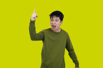 Excited young asian Man Celebrating Success in Front of a Vibrant Yellow Background