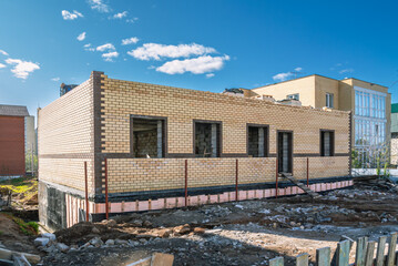 Obraz premium Building a brick house. Brickwork during the construction of the building. The territory of the house under construction.