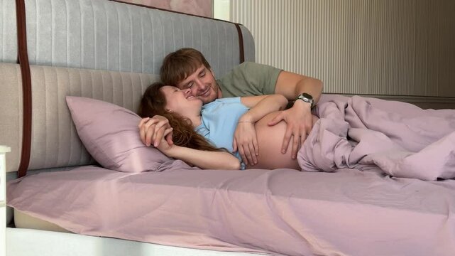 beautiful young couple in love man and pregnant woman in bed in the morning, enjoying each other. concept happy relationship