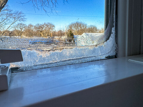 Ice collecting on the inside of a window on an extremely cold winter day 