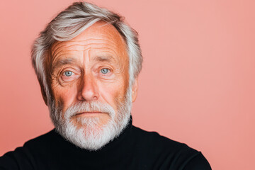 Obraz premium Portrait of an older man with a serious expression and gray hair against a pastel pink background