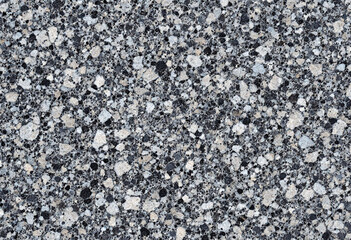 Obraz premium A speckled granite stone texture in shades of black, white, and gray, with a rough, natural finish