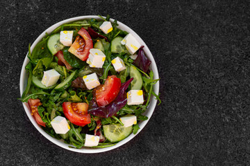 Fresh Salad with Tomatoes, Feta, and Arugula on Dark Background, Top View