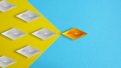 Social media followers or standing out from the crowd concepts. White paper ships moving towards...