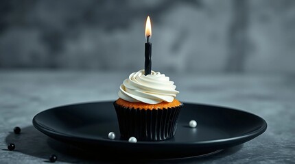 A single monochrome cupcake with pure white frosting and a sleek black candle, placed to the side of a matte black ceramic plate