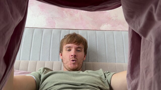 man looking under blanket and happy, feeling excited, concept men's health, bed