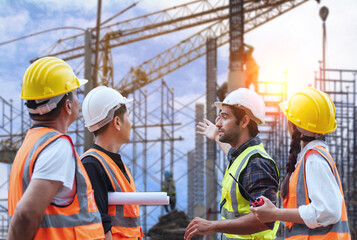 A diverse group of construction workers in safety gear discussing plans on an active building site...
