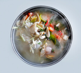 Hot Spicy and sour seafood soup served in steamer with smoke rising, top view directly above, seafood meal in Thai local restaurant
