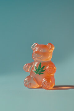 close-up of a translucent gummy bear with a cannabis leaf design on its chest, set against a soft pastel background