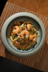 Seafood pasta with shrimps in bowl on wooden table