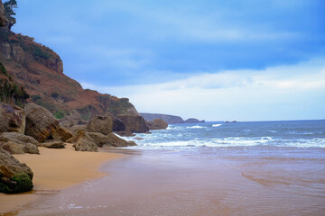 A rocky beach with a cloudy sky in the background.